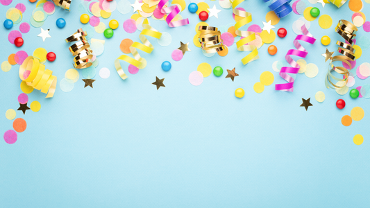 Colorful party supplies, confetti, and streamers on light blue background